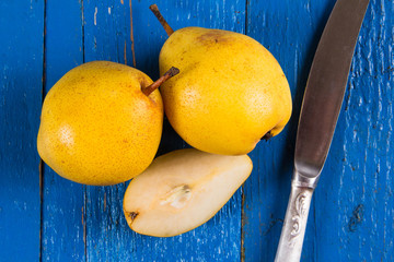 Fresh ripe organic yello pears on blue rustic wooden table, natural background, diet food.