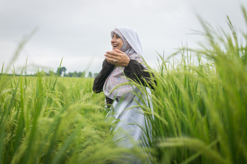 Wall Mural - Beautiful happy Muslim woman in green field