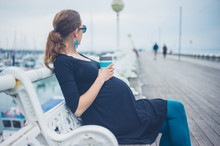 Pregnant Woman With Cup On The Pier