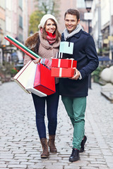 Wall Mural - Happy couple shopping for Christmas in the city