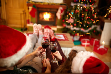 Wall Mural - Couple toasting with glasses of red wine for Christmas