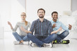 © Yakobchuk Olena - Business people doing yoga on floor in office