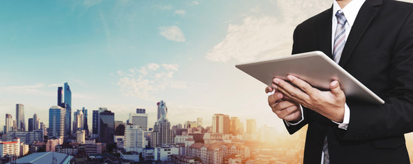 Sticker - Businessman working on digital tablet outdoor, and city panoramic background