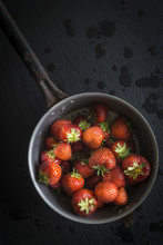 Strawberries In Vintage Colander On Black Slate. Top View