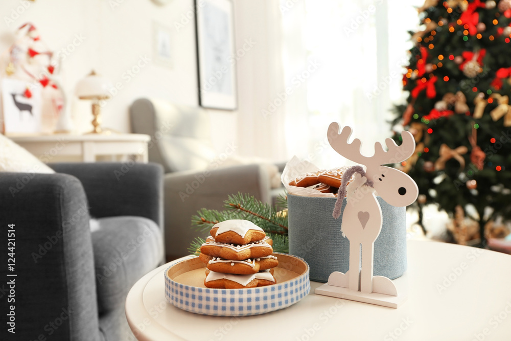 Tasty gingerbread cookies, Christmas decor and box on table against blurred background