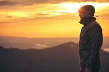 Young Man Standing Alone Outdoor With Sunset Mountains On Background Travel Lifestyle And Survival Concept