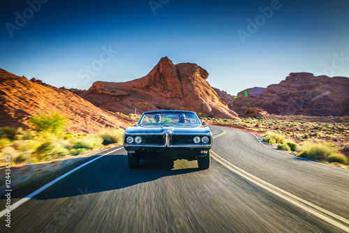 Fotografía driving fast through desert in vintage hot rod car