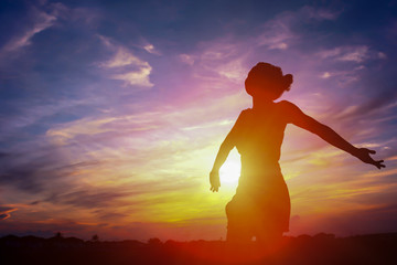 silhouette of a happy woman and sunset