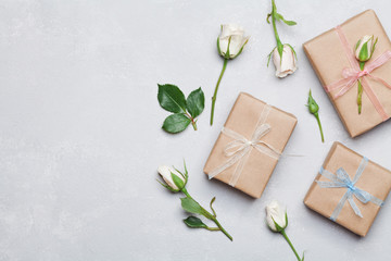 Wall Mural - Gift or present box wrapped in kraft paper and rose flower on gray table from above. Flat lay styling. Copy space for text.