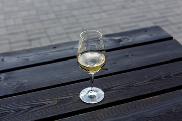 A glass of white wine on the black wooden table