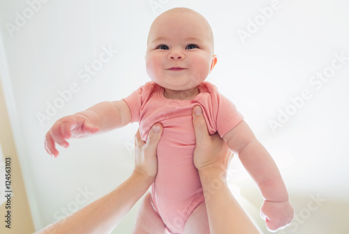 Fotografie, Obraz Happy infant baby girl being held up in the air