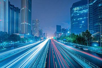 blurred traffic light trails on road at night in China.