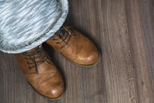 Two Brown Boots With Grey Hat On The Wooden Background