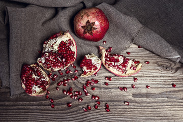 Still life with fresh juicy pomegranate on sackcloth on on rusti