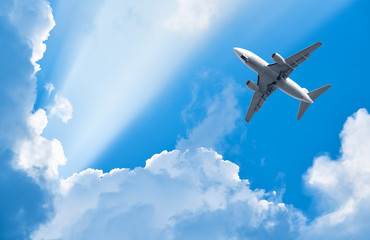 Photo Sur Toile - plane is flying among clouds in rays of sun