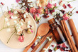 Essential oil of rose, cinnamon, anise mix. Herbal aroma beauty care. Dropper bottle, dried fragrant flowers, sticks, wooden utensils, top view background.