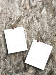 Two blank square photo frames on wood