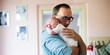 © Halfpoint - Young father holding newborn baby son in his arms