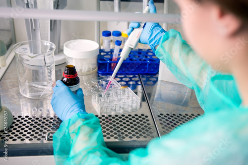 Fotografie, Tablou Conducting research work on cancer in laboratory, pipetting samp