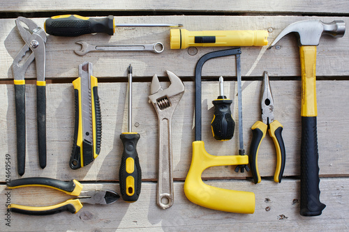 Fotografia, Obraz Top view of a set of tools lying on a table of wooden planks