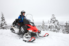 Happy Smiling Man Driving Snowmobile In Finnish Lapland