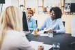 © SFIO CRACHO - Beautiful womans laughing at business meeting in modern office. Group girls coworkers discussing together new fashion project. Horizontal, blurred background.