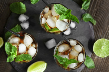 Canvas Print - Glasses of cocktail with ice and mint on wooden table, top view