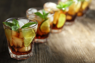 Canvas Print - Glasses of cocktail with ice and mint on wooden background