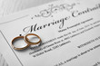 Golden wedding rings on marriage contract, closeup
