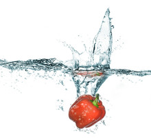Sweet Red Pepper In Water With Splash. Isolated