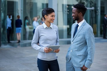 Wall Mural - Businessman and colleague interacting in office building