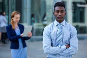 Wall Mural - Businessman standing with arms crossed in office building