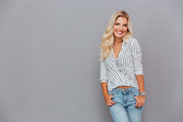 Poster - Portrait of a smiling woman standing with hands in pockets