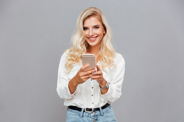 Poster - Smiling beautiful woman holding mobile phone