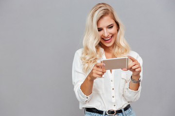 Canvas Print - Cheerful young woman using mobile phone