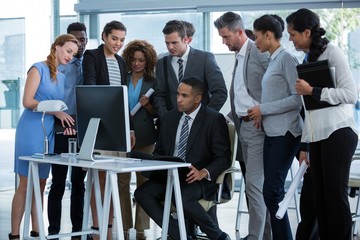 Wall Mural - Group of businesspeople discussing over computer