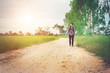 © Johnstocker - Young hipster man with backpack on his shoulder walking down cou