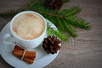 Cup of coffee and brown pine cone on wooden table