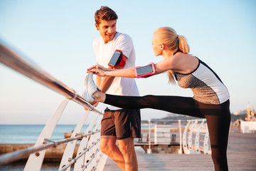 Sticker - Young couple doing stretching exercise and warming up before jogging