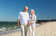 © Syda Productions - happy senior couple holding hands on summer beach
