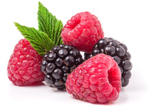 Pile Of Raspberries And Blackberries With Leaves Isolated On White Background