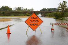 Road Closed Ahead Sign Over Rain Flooded Street