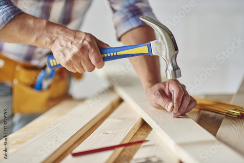 Photographie Carpenter with hammer hitting nails.