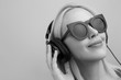 © Myvisuals - beautiful happy woman in headphones listening music near the wal