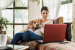 © cherryandbees - woman relaxing on the sofa with her dog and using tablet