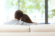 Couple sitting on a couch looking through window