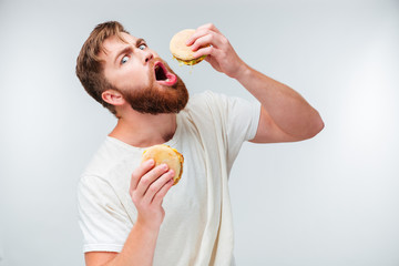 Sticker - Excited bearded man greedily eating hamburgers