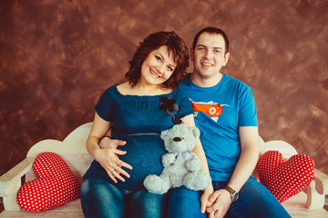 Wall Mural - Pretty pragnant lady sits on white bench with her man