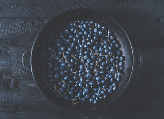 Wall Mural - Blueberries on vintage wooden black background top view, healthy food on dark table mockup, berry for smoothie isolated on rustic country board, fresh nutrition closeup, copy space for text design