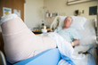 © Mat Hayward - patient lying in hospital bed with broken leg bone wrapped in ca